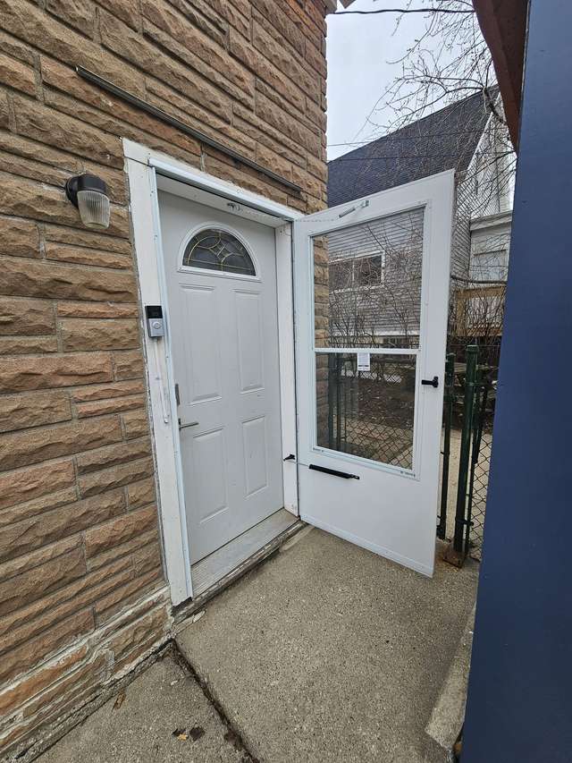 Exterior entry door and storm door at a residential property.