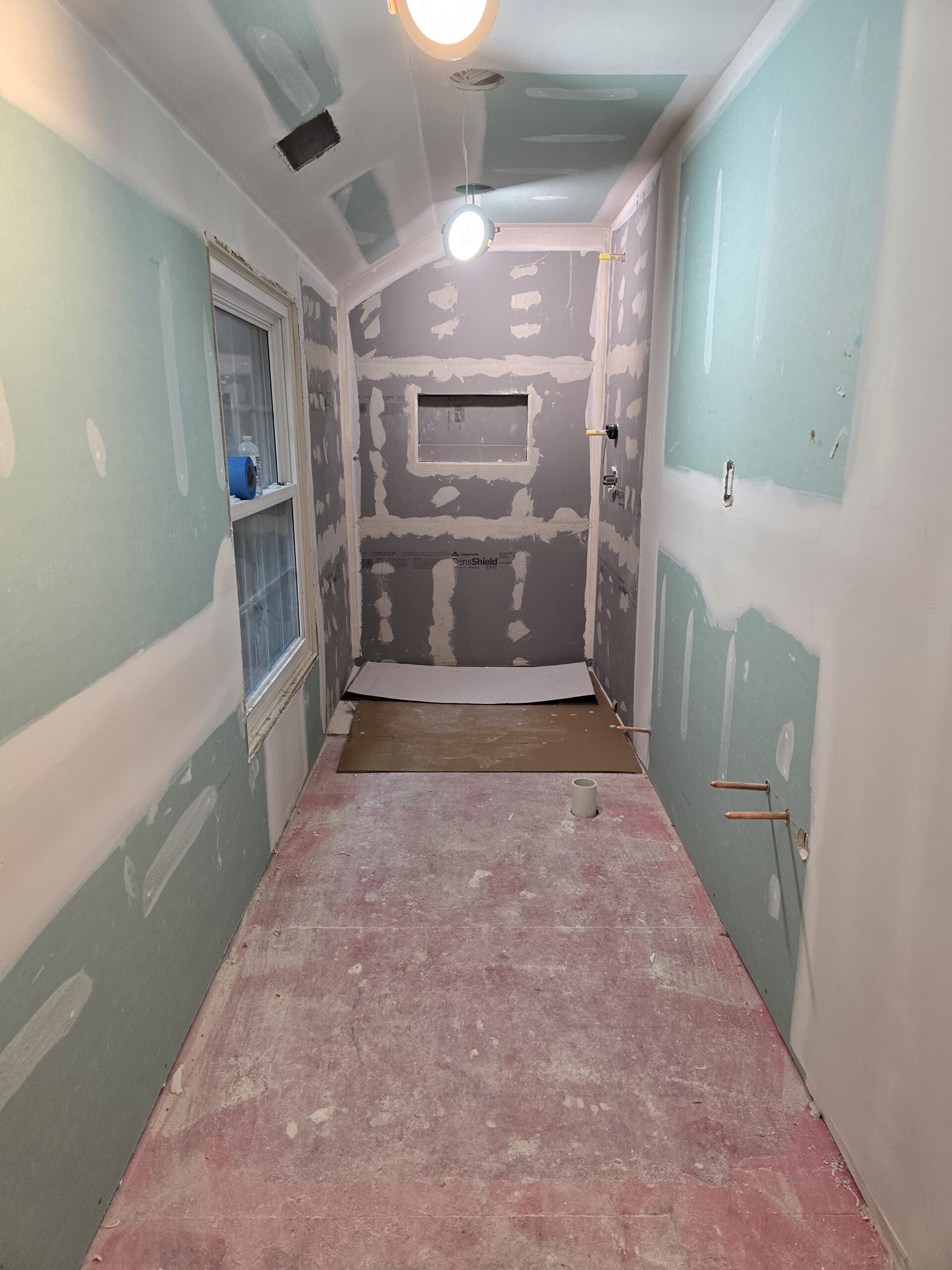 Walk-in shower prepared with cement backer board and waterproof substrate before tile installation