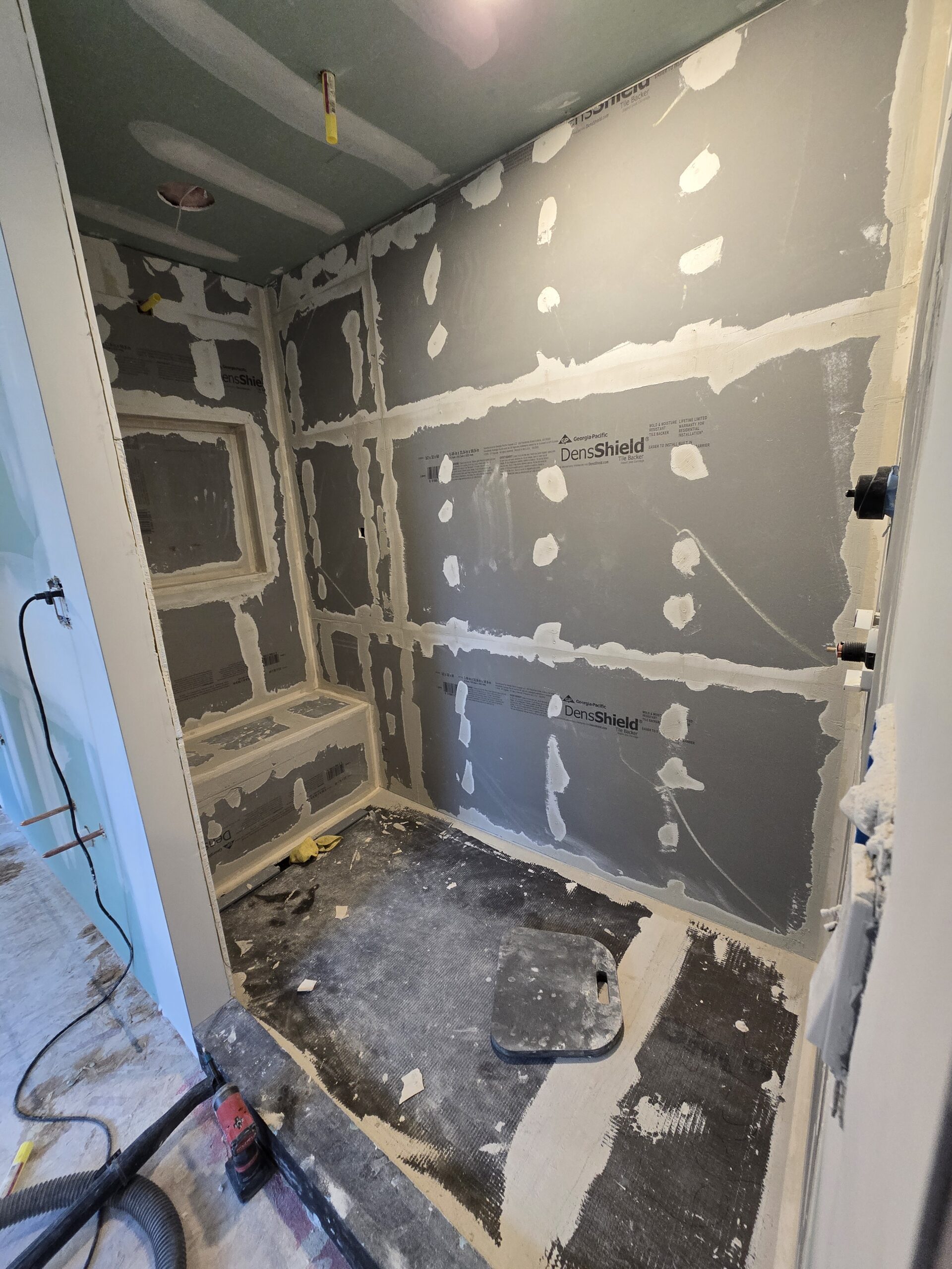 Walk-in shower waterproofing system installed before tile installation during luxury bathroom remodel