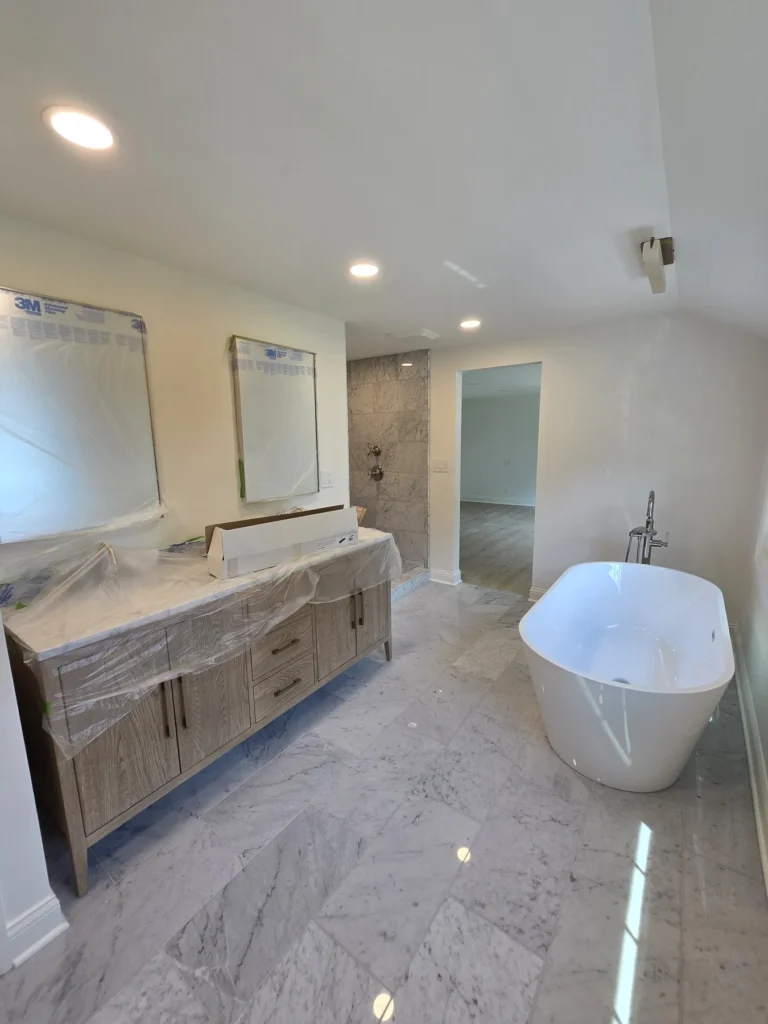 Luxury bathroom remodel with freestanding tub, marble tile flooring, custom vanity, and walk-in shower by GetFix4U