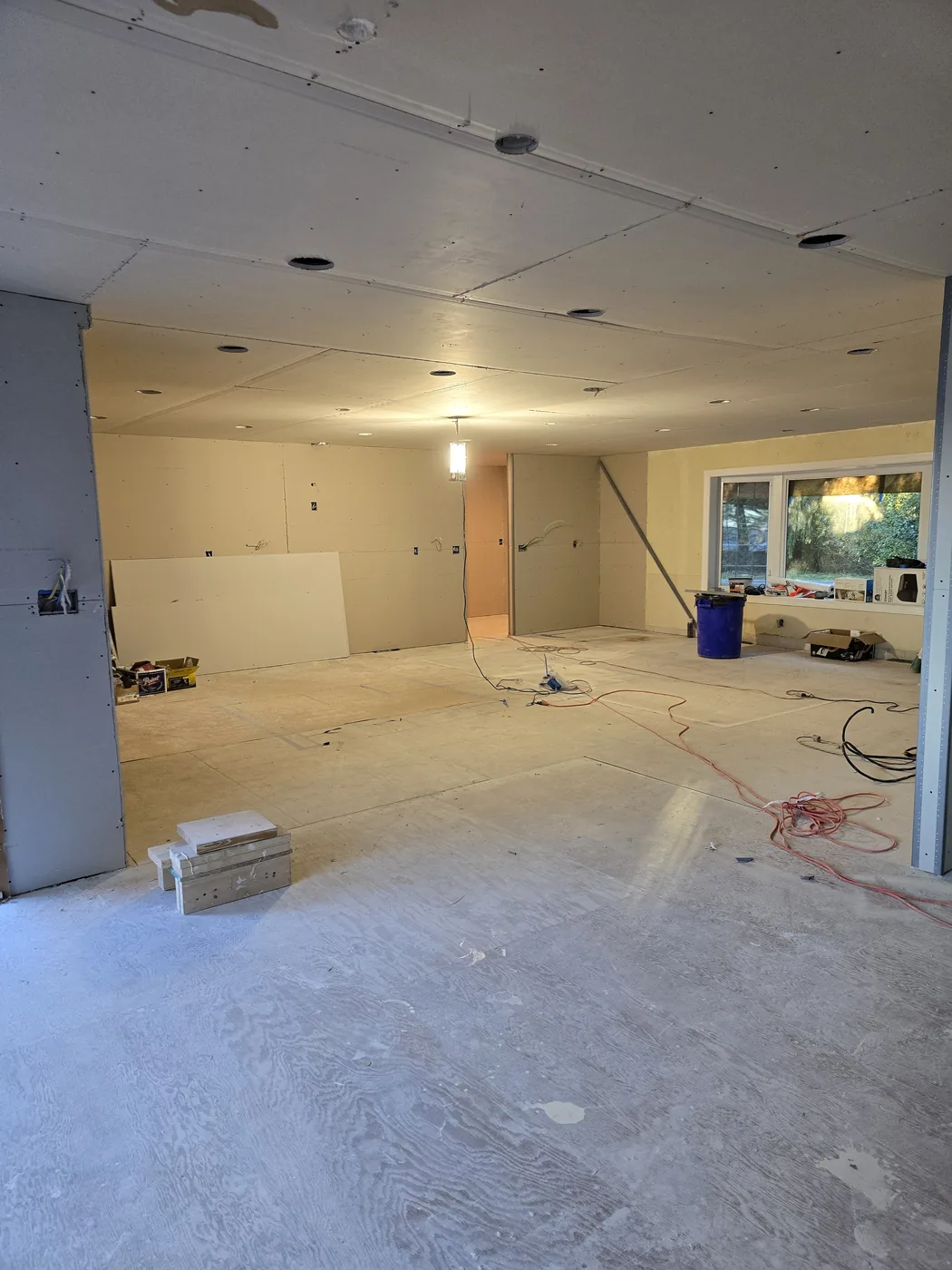 Room at bare drywall stage with exposed studs, wiring, and construction debris, before cabinetry.