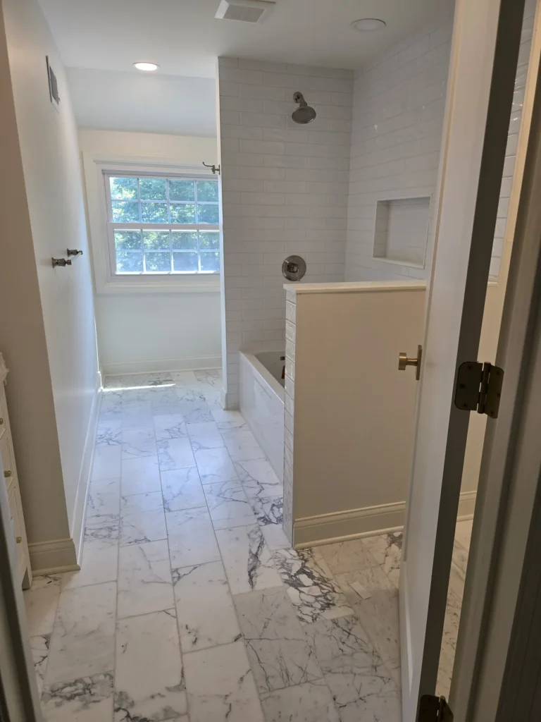White tile tub and shower remodel with custom niche, subway tile, and modern bathroom finishes by GetFix4U